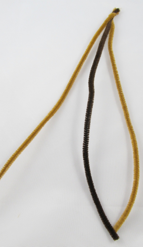 Braid two light brown and one dark brown pipe cleaners together. Repeat so that you have two braids. Twist these two together. For branches twist single pipe cleaners onto the thicker branch. For leaves, fold a green pipe cleaner into 3/4 inch segments. Fan these out into a star shape and attach them to the branch.