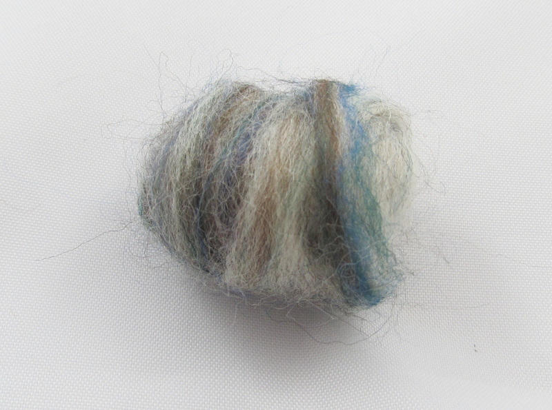 Roll it into a ball. Attach it to the loose end of the body by needling.